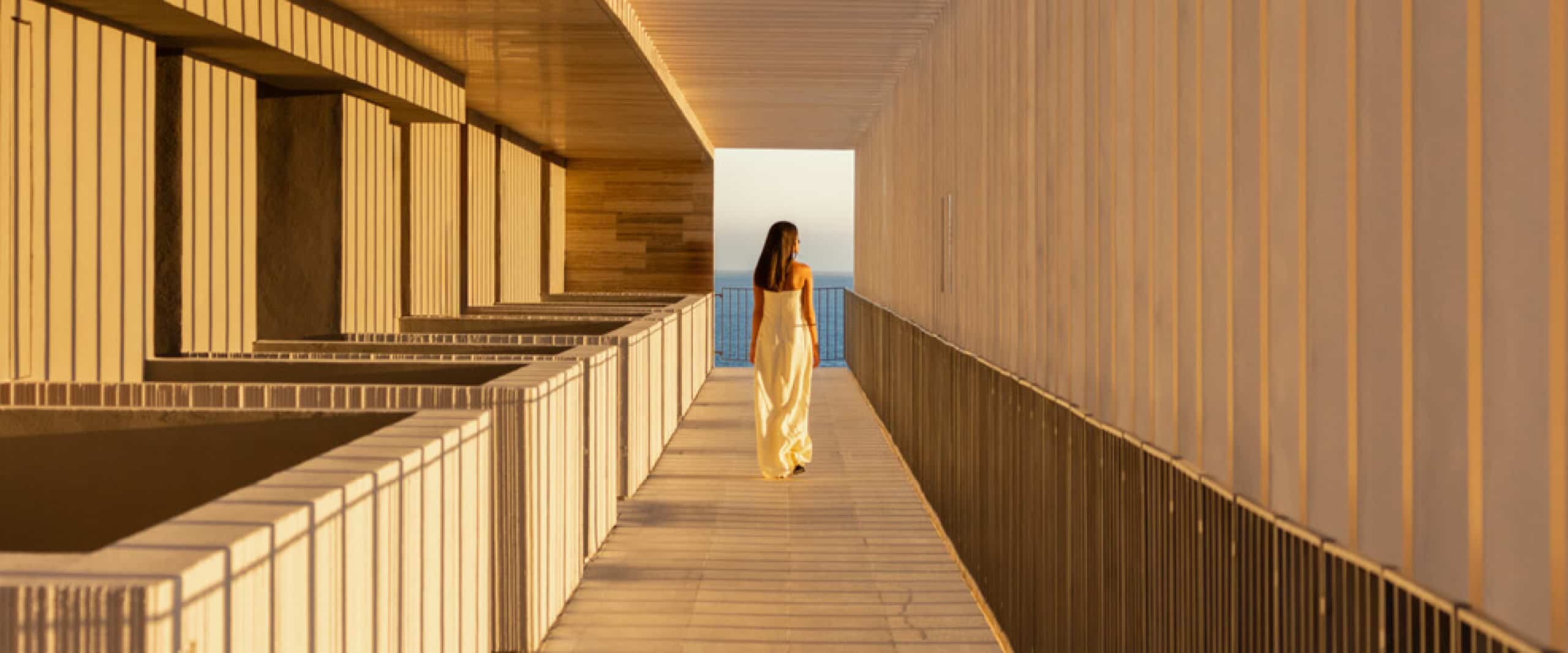 Luxury Collection Hero with woman walking along balcony